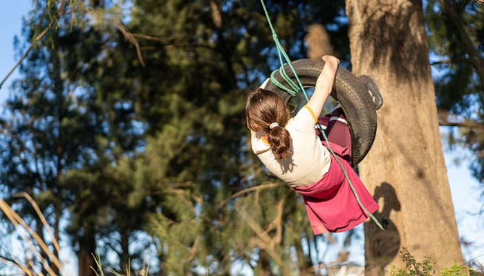 Child playing on a tyre swing