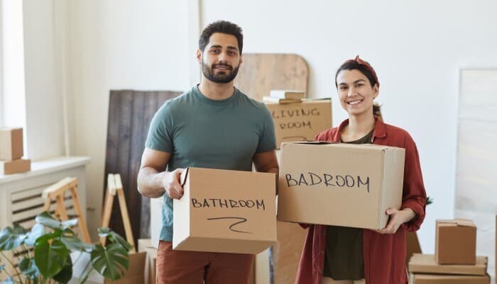 Couple holding labled moving boxes