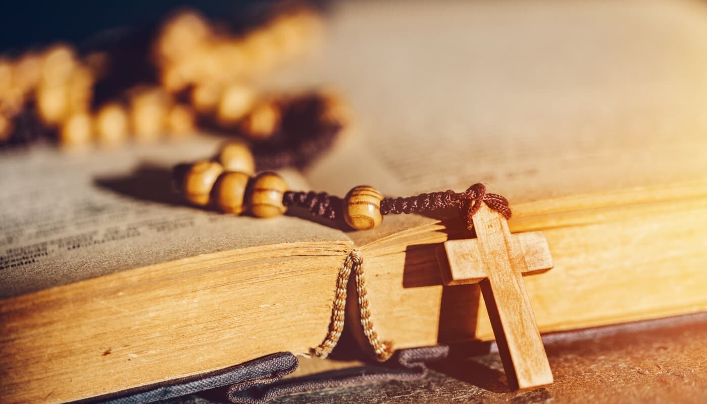 Rosary with cross laying on a bible book